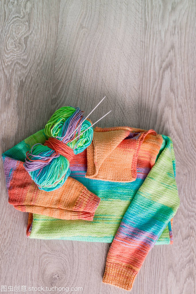 針織。針織毛衫。多色球的紗線用針附近上木制的灰色背景的手工產品。頂視圖。復制空間